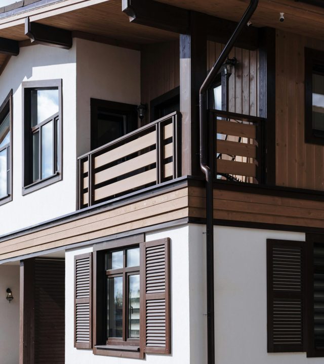 Contemporary suburban house exterior with wooden accents and shutters.